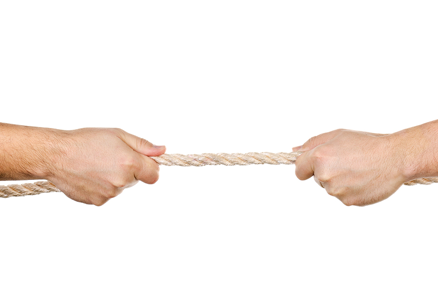 Two men pulling a rope in opposite directions isolated