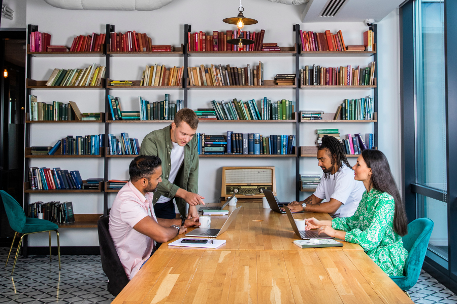 A team of four working together on a table in a coworking space in London. 